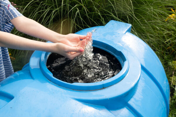 Bild vergrößern: Hnde schpfen Wasser aus einem Tank